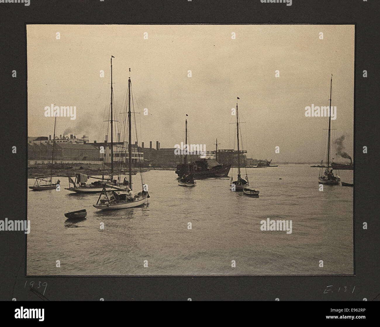 Cette photographie historique représente des voiliers et des bâtiments commerciaux dans un port, situé pendant la guerre sino-japonaise (1937-1945). Il met en lumière le mélange du commerce maritime et de l'impact du conflit sur les zones côtières au cours de la période. Banque D'Images