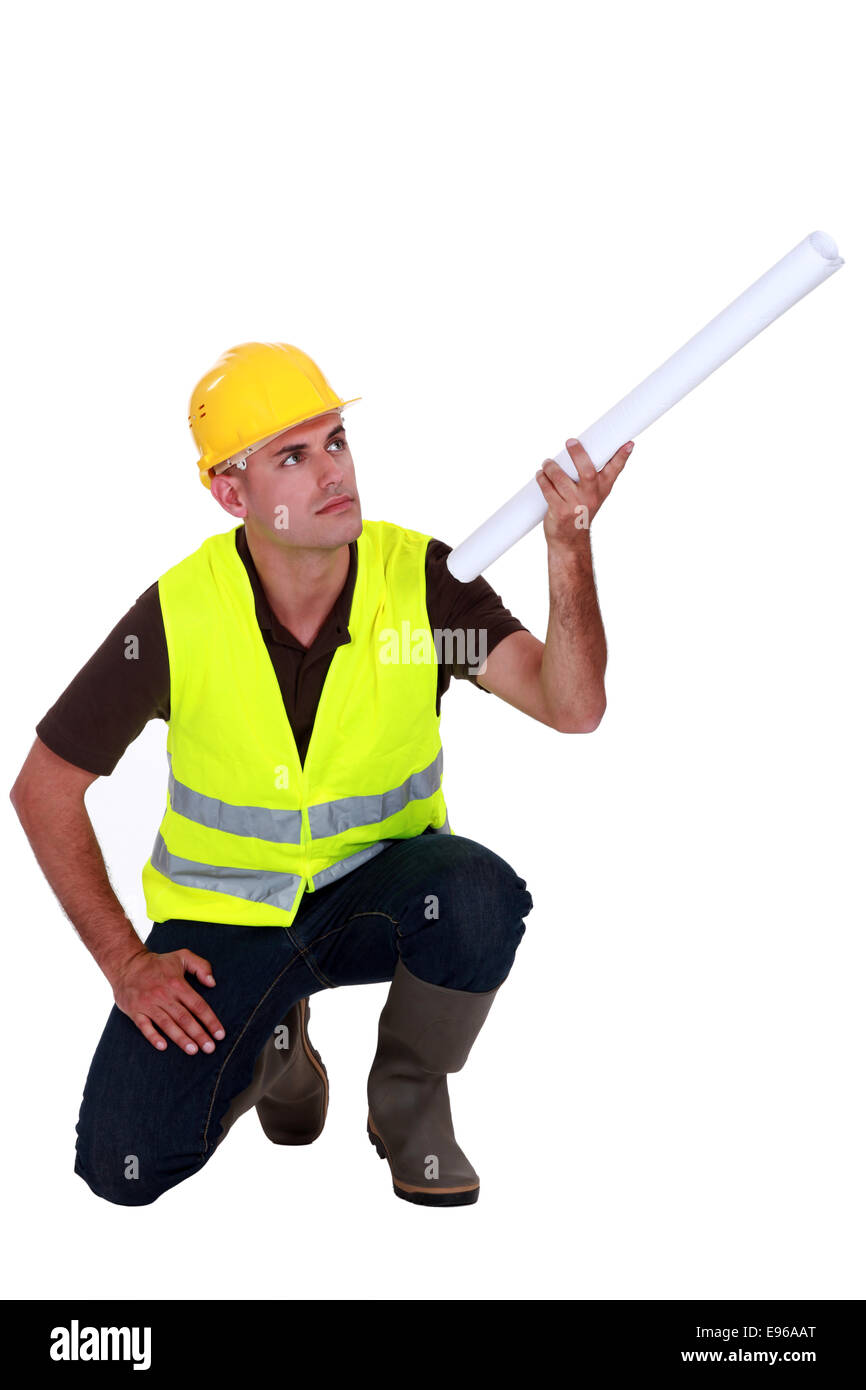 Commerçant holding up a rolled-up plan Banque D'Images