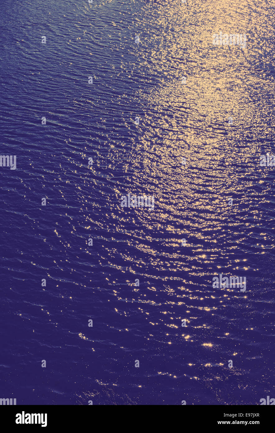 Vintage photo filtrée de rayons de soleil reflété sur une surface de l'eau. Banque D'Images