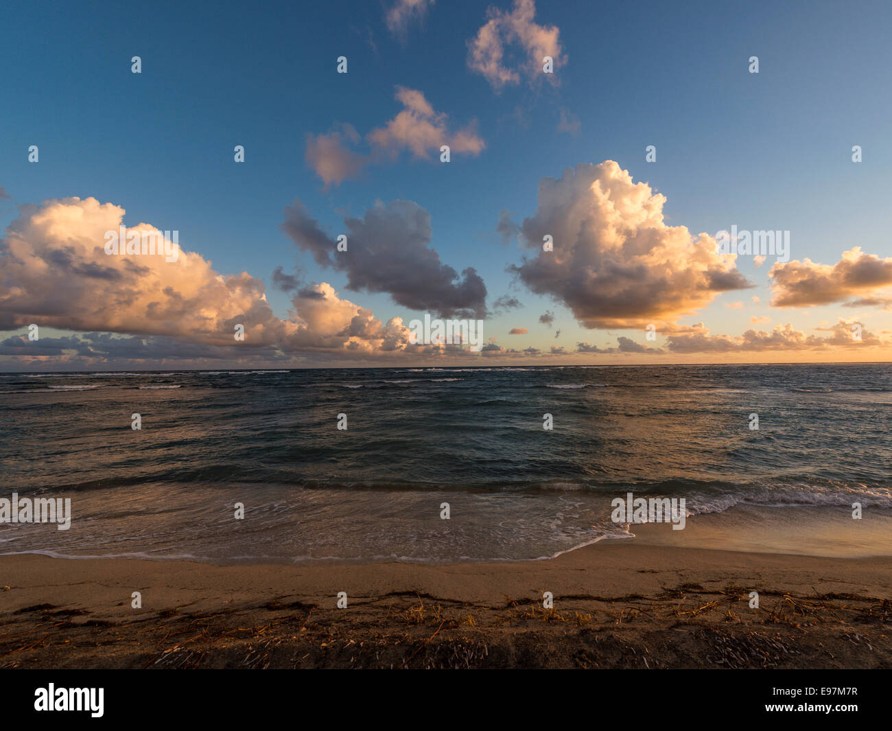 Paysage - Lever de soleil réfléchissant la lumière sur une formation nuageuse avec de longs courriers Bay Beach et la mer des Caraïbes à l'avant-plan. Banque D'Images