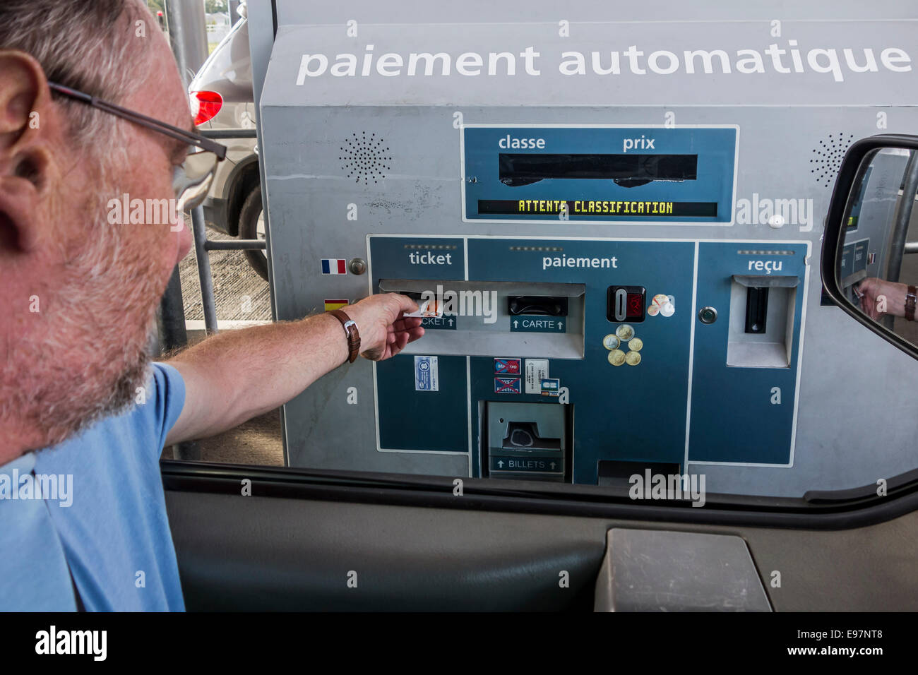 Voiture pilote dans la mise en automatique de billets / péage électronique machine avant de payer par carte de crédit au péage Banque D'Images