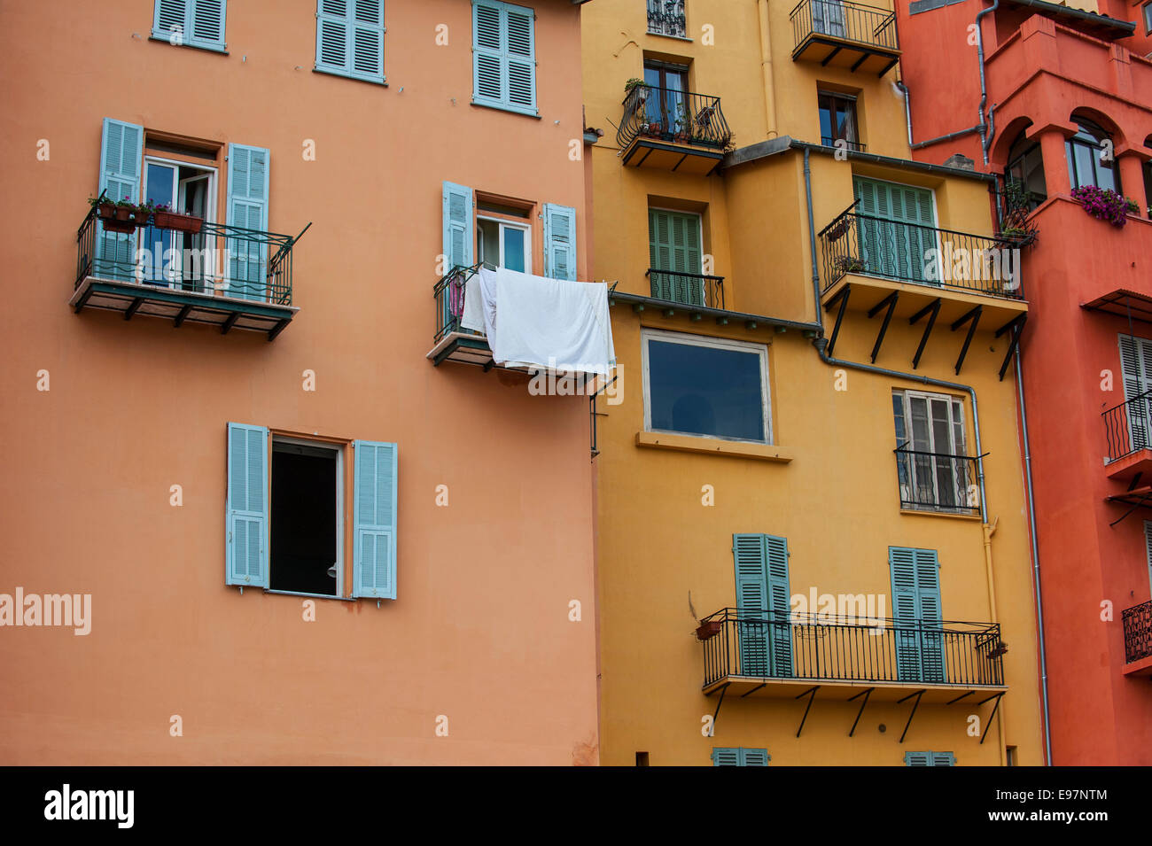 Les balcons et les fenêtres avec stores de couleur pastel des maisons dans la ville Menton le long de la Côte d'Azur, la Côte d'Azur, France Banque D'Images