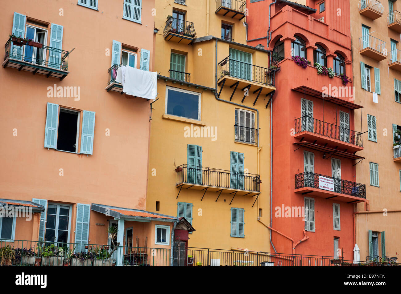 Les balcons et les fenêtres avec stores de couleur pastel des maisons dans la ville Menton le long de la Côte d'Azur, la Côte d'Azur, France Banque D'Images