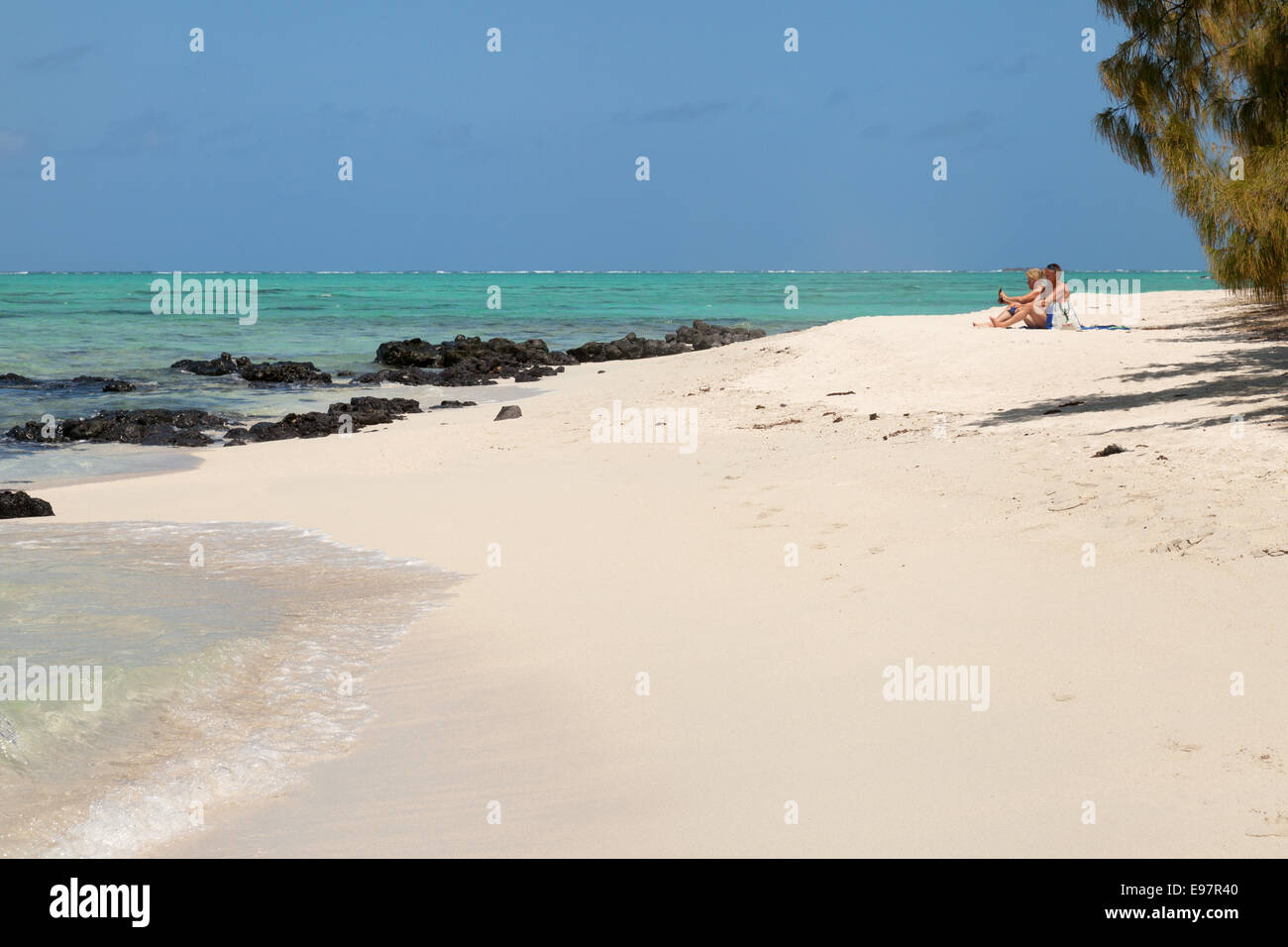 Un couple sur la plage de sable blanc, l'Île aux Cerfs, île Maurice, Côte est de l'Afrique Banque D'Images