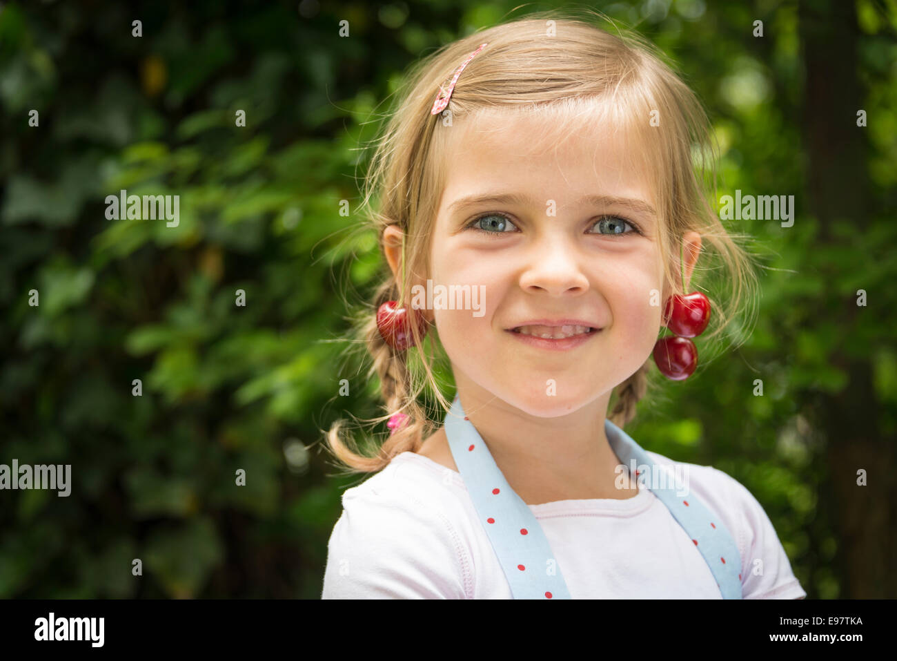 Portrait de petite fille, les cerises se balançant d'oreilles Banque D'Images