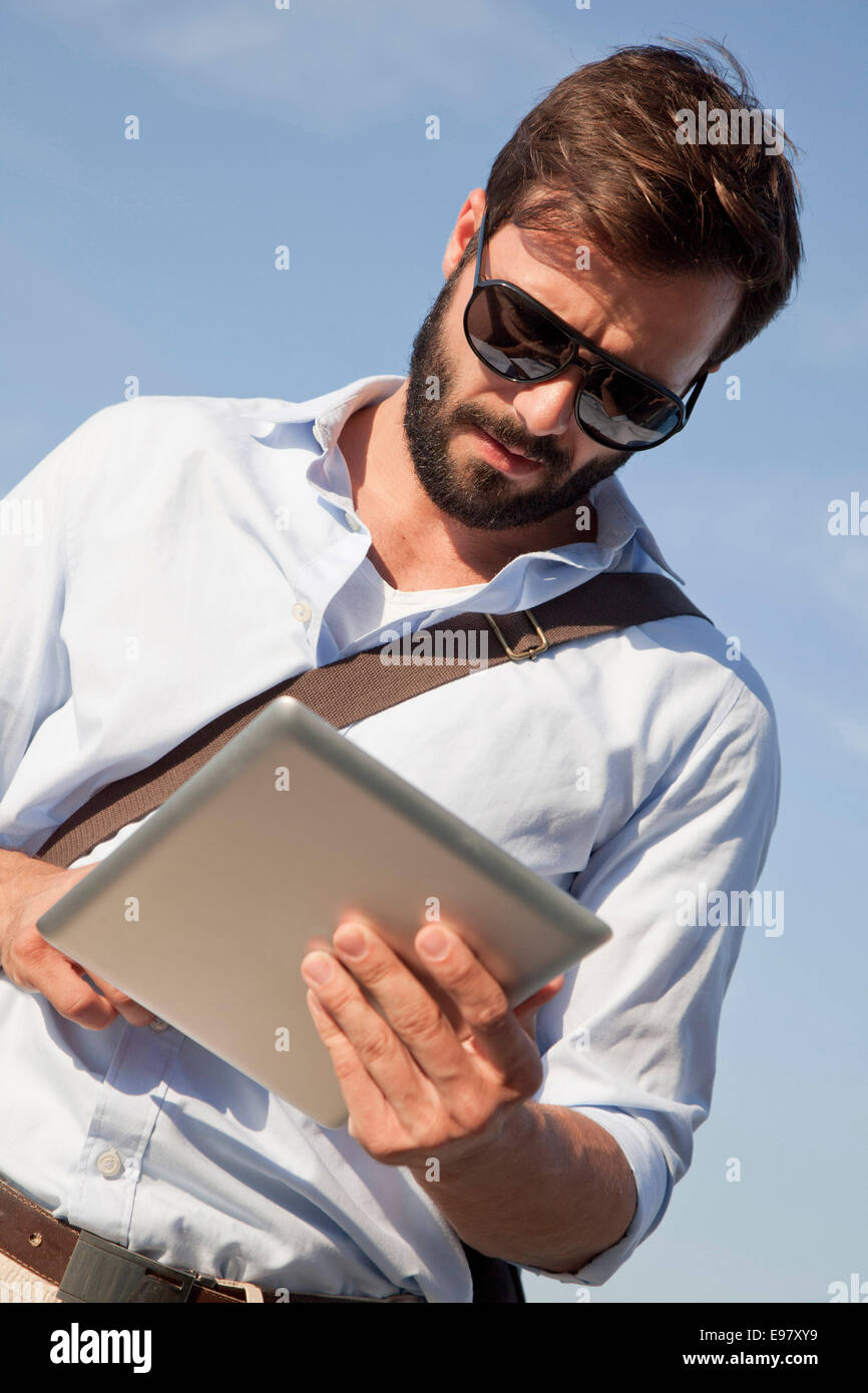 Young man using digital tablet outdoors Banque D'Images