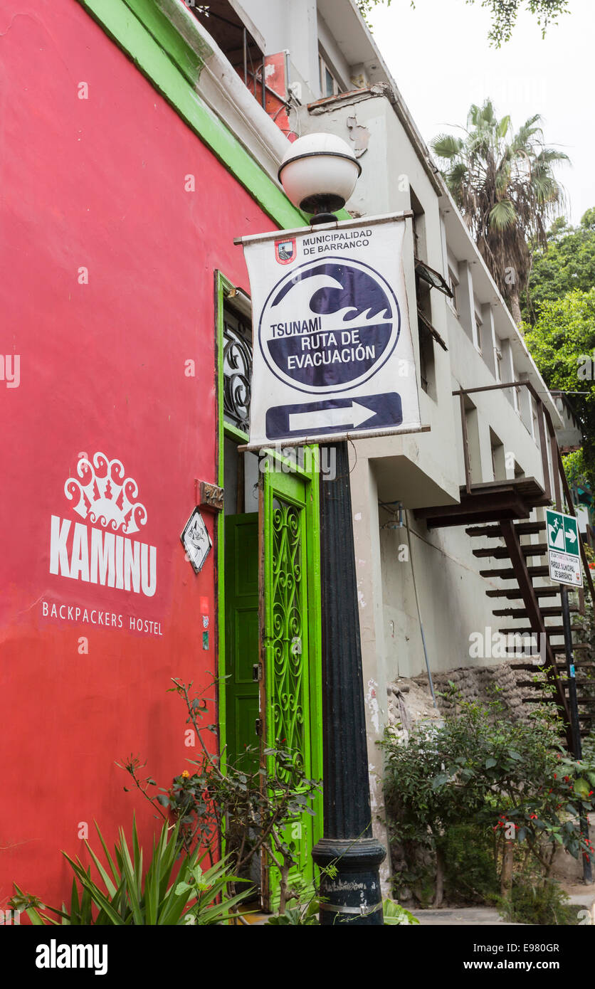 Panneau de route d'évacuation du tsunami à l'extérieur d'une auberge de routards dans la banlieue côtière de Barranco, Lima, Pérou Banque D'Images