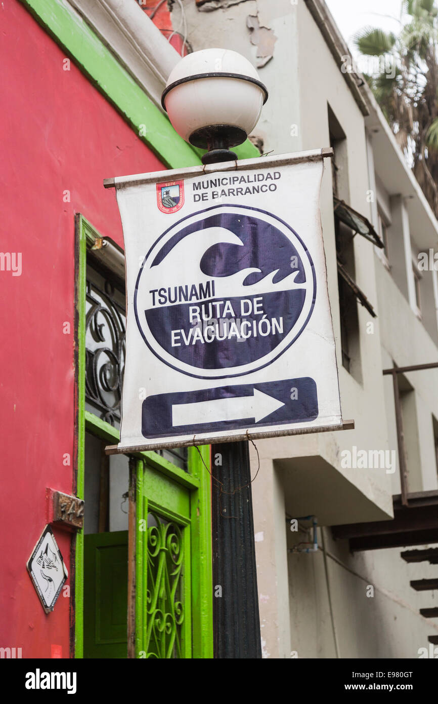 Panneau de route d'évacuation du tsunami à l'extérieur d'une auberge de routards dans la banlieue côtière de Barranco, Lima, Pérou Banque D'Images