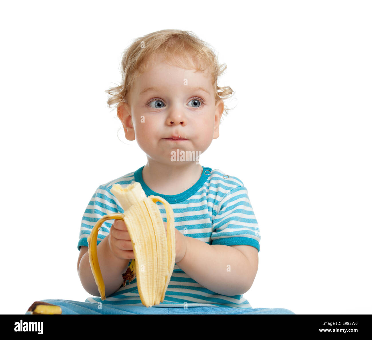 Kid boy eating banana isolated Banque D'Images