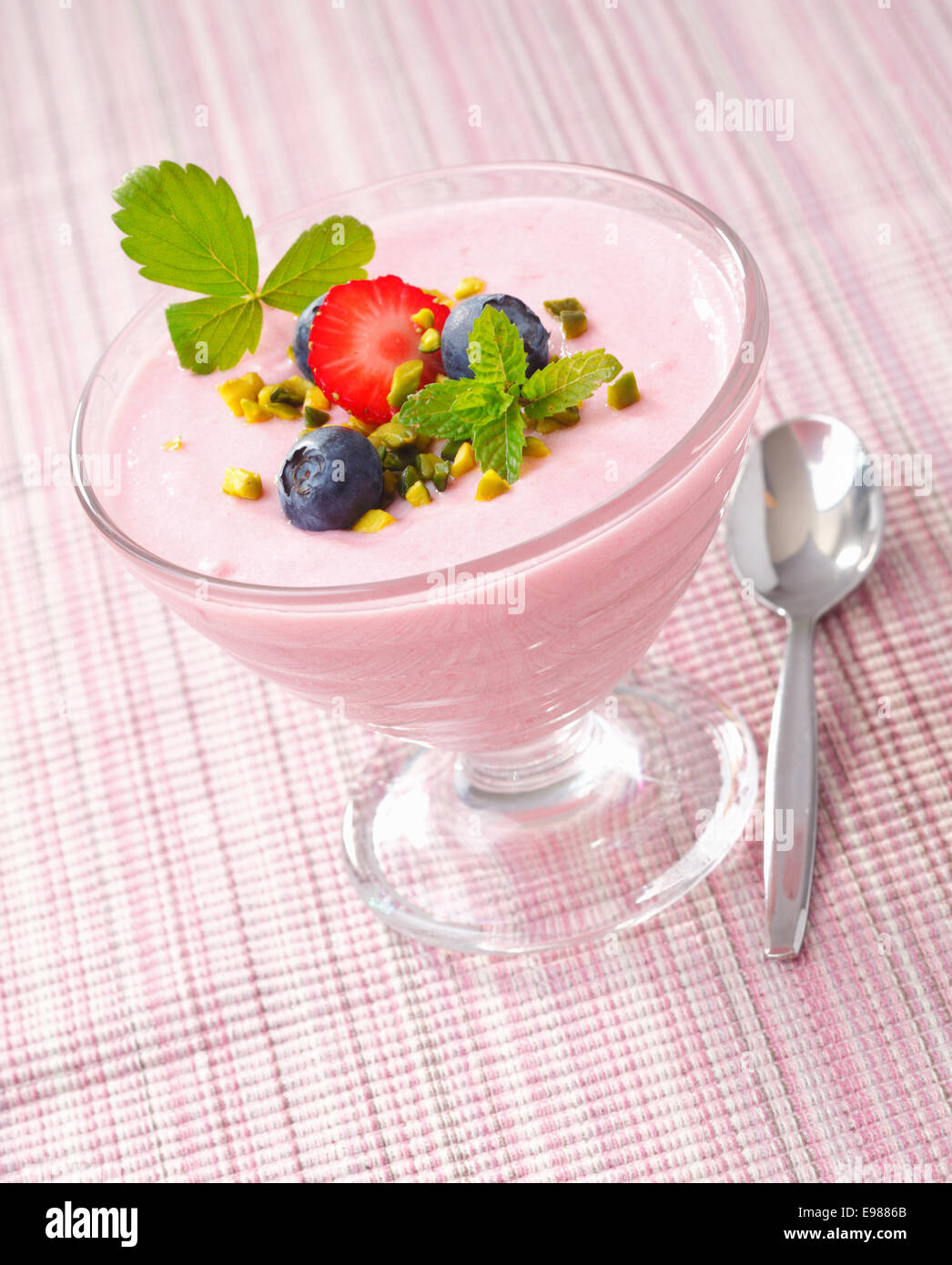Petits fruits froid servi dans un bol en verre avec crème aux fraises et bleuets topping. Banque D'Images