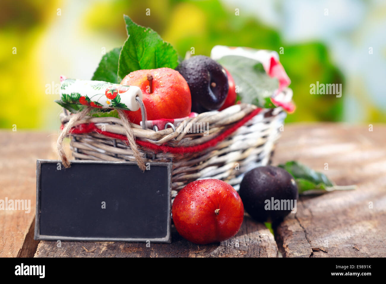 Affichage de pourpre et de prunes rouges frais à un marché de producteurs en plein air avec un petit tableau noir en blanc pour votre description et prix Banque D'Images