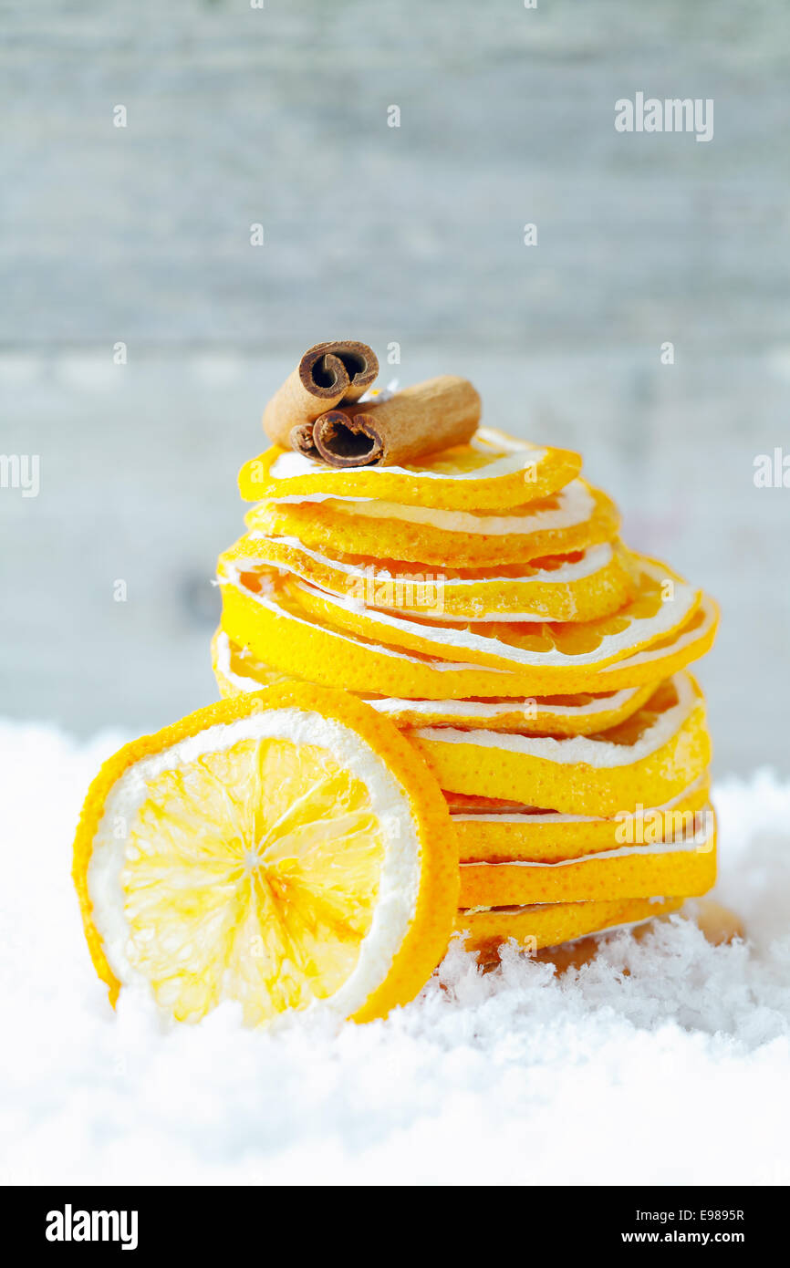 Une pile de tranches d'orange séchée et la cannelle sur la neige pour assaisonner vos breuvages et de dessert pendant un hiver froid Banque D'Images