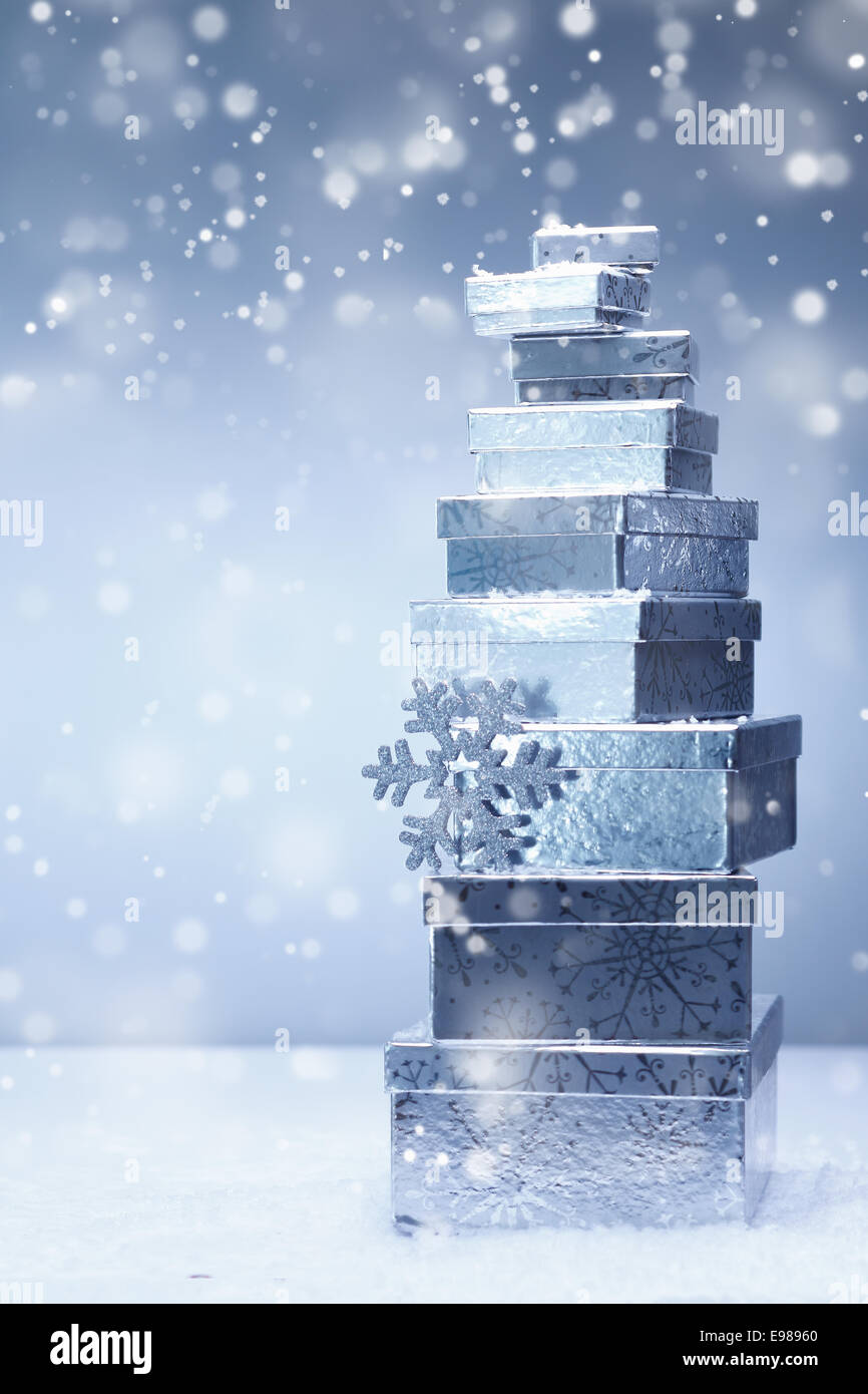 Une tour d'argent empilées les cadeaux de Noël par la diminution des tailles et différents angles en chute de neige avec copyspace Banque D'Images