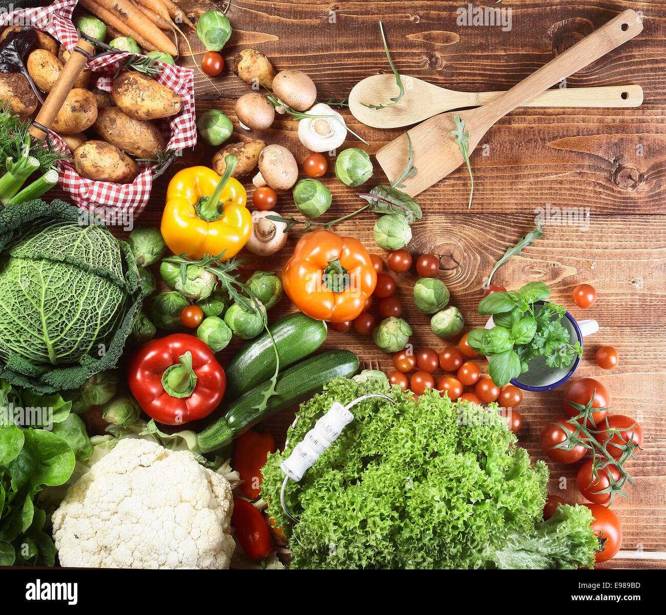 Vue de dessus de toute une gamme d'Herbes et légumes frais de la campagne sur une surface cuisine en bois prêt à être utilisés comme ingrédients dans la cuisine végétarienne Banque D'Images