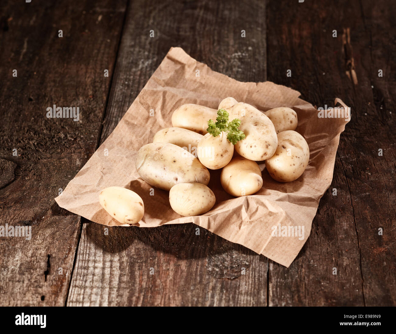 Laver Les Pommes De Terre Fraîches Ferme Affichée Sur Papier Brun Froissé Sur Une Table En Bois