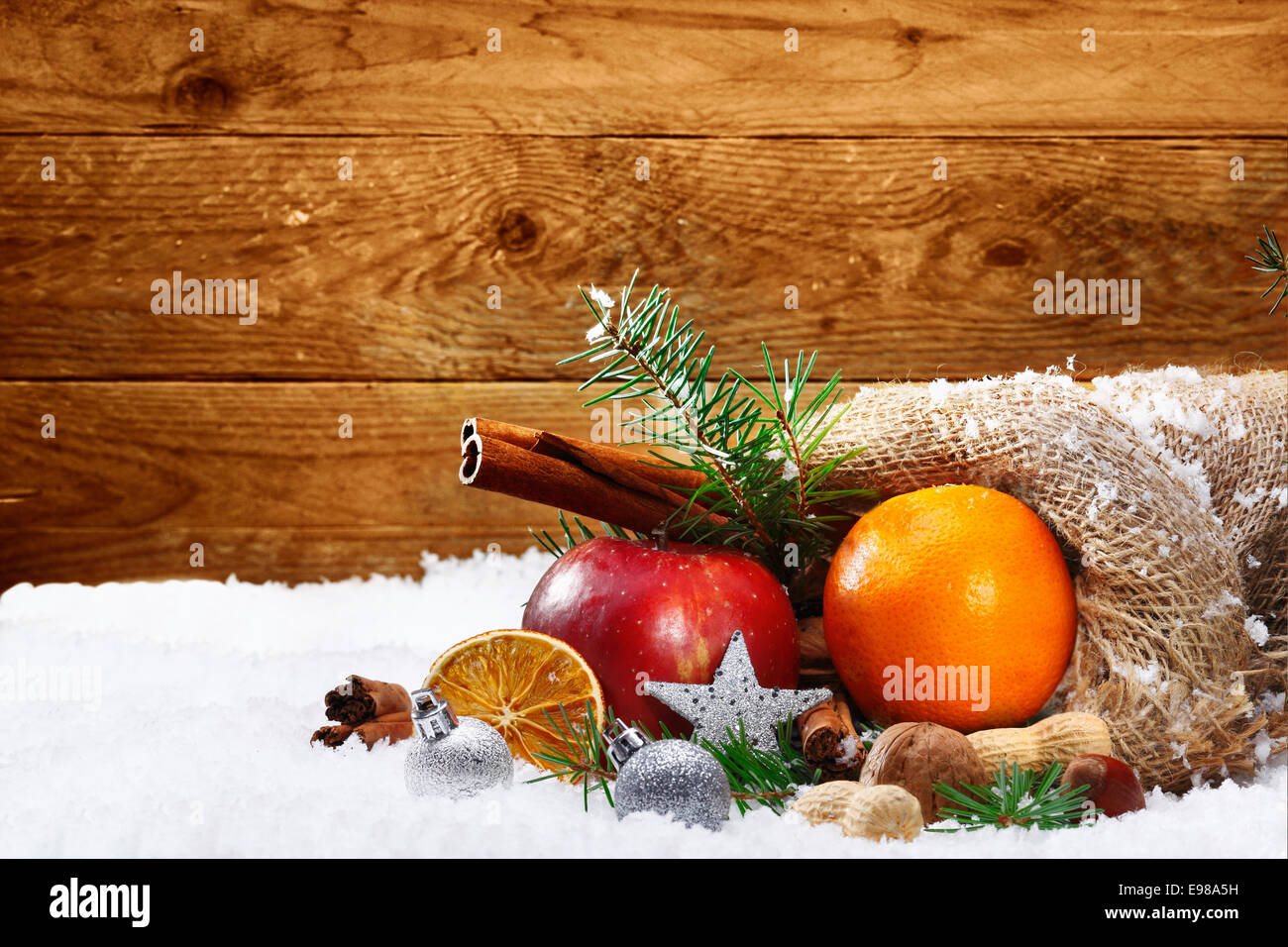 Noël encore la vie artistique de fruits et d'épices colorées s'échappant  d'un sac de toile rustique sur neige de l'hiver avec une planche en bois et  fond copyspace Photo Stock - Alamy