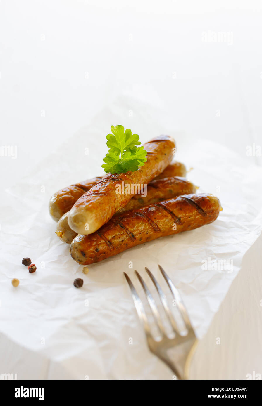 Fumé et grillé bratwurst fourche contre le fond blanc Banque D'Images