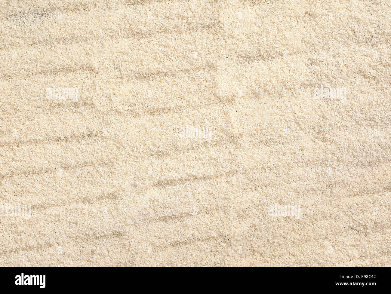Texture de fond soulevée par le vent de sable de plage dorée ondulée avec une texture granuleuse et vague Banque D'Images