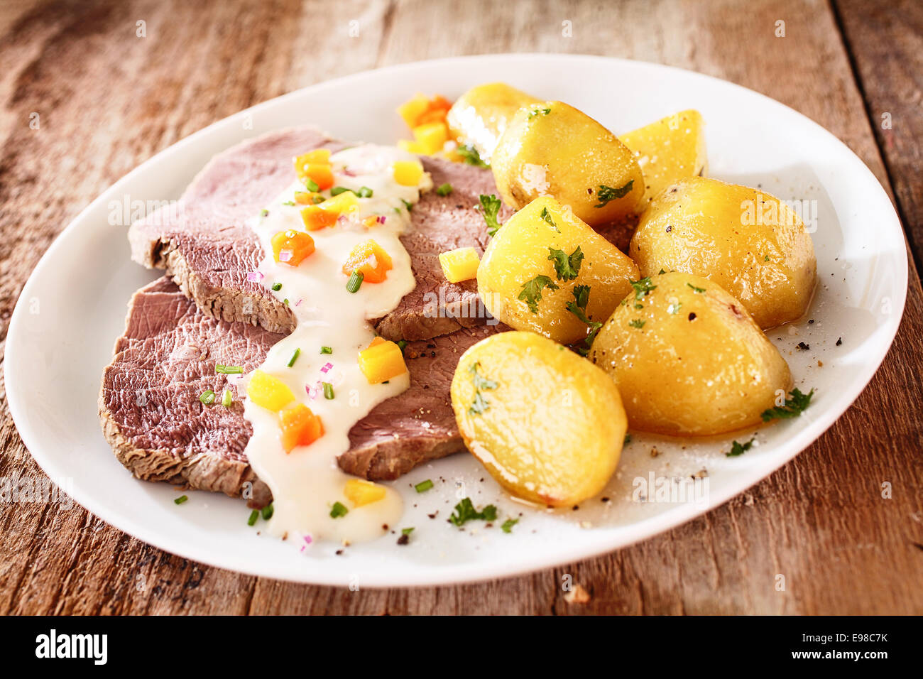 Les tranches de maigre croupe servi avec pommes Golden Delicious saupoudré de persil haché et recouvert de crème sure ou crémeuse sauce moyonnaise Banque D'Images