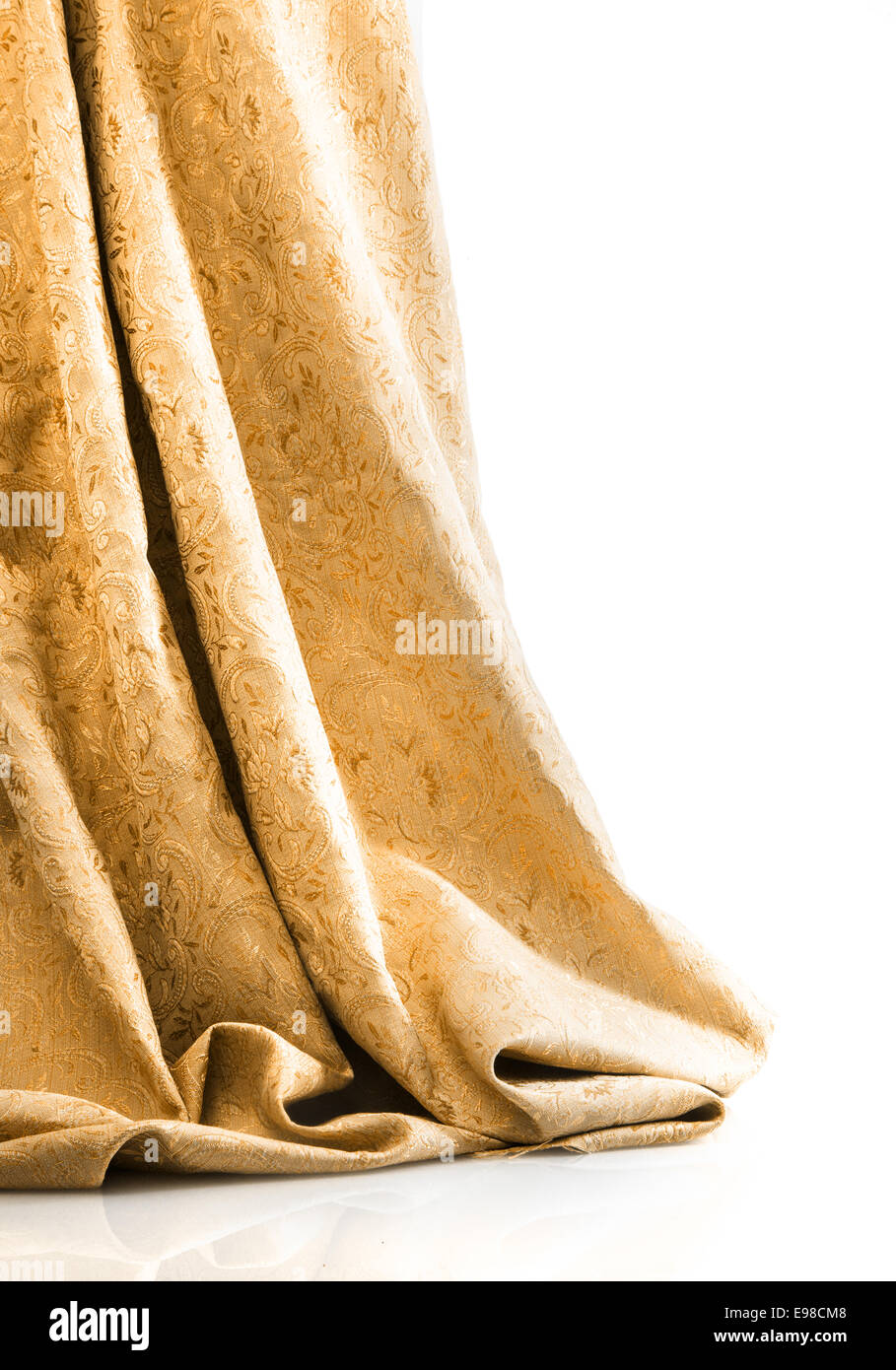 Or élégant damask brocade ou accroché au sol dans des rideaux de luxe sur un fond blanc avec copyspace Banque D'Images