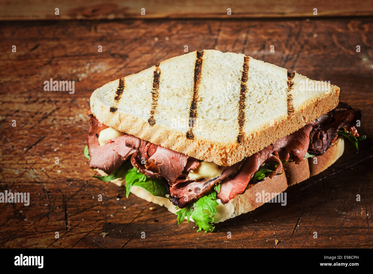 Sandwich grillé d'un barbecue avec un rôti de boeuf et légumes verts frais herbes sur une table en bois rustique Banque D'Images