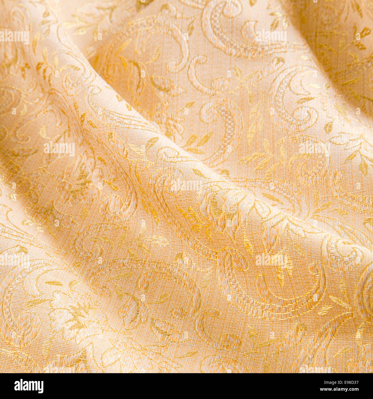 Or luxueux tissu damassé avec un ensemble de feuilles d'acanthe drapés dans une élégante manière diagonale avec plis doux Banque D'Images