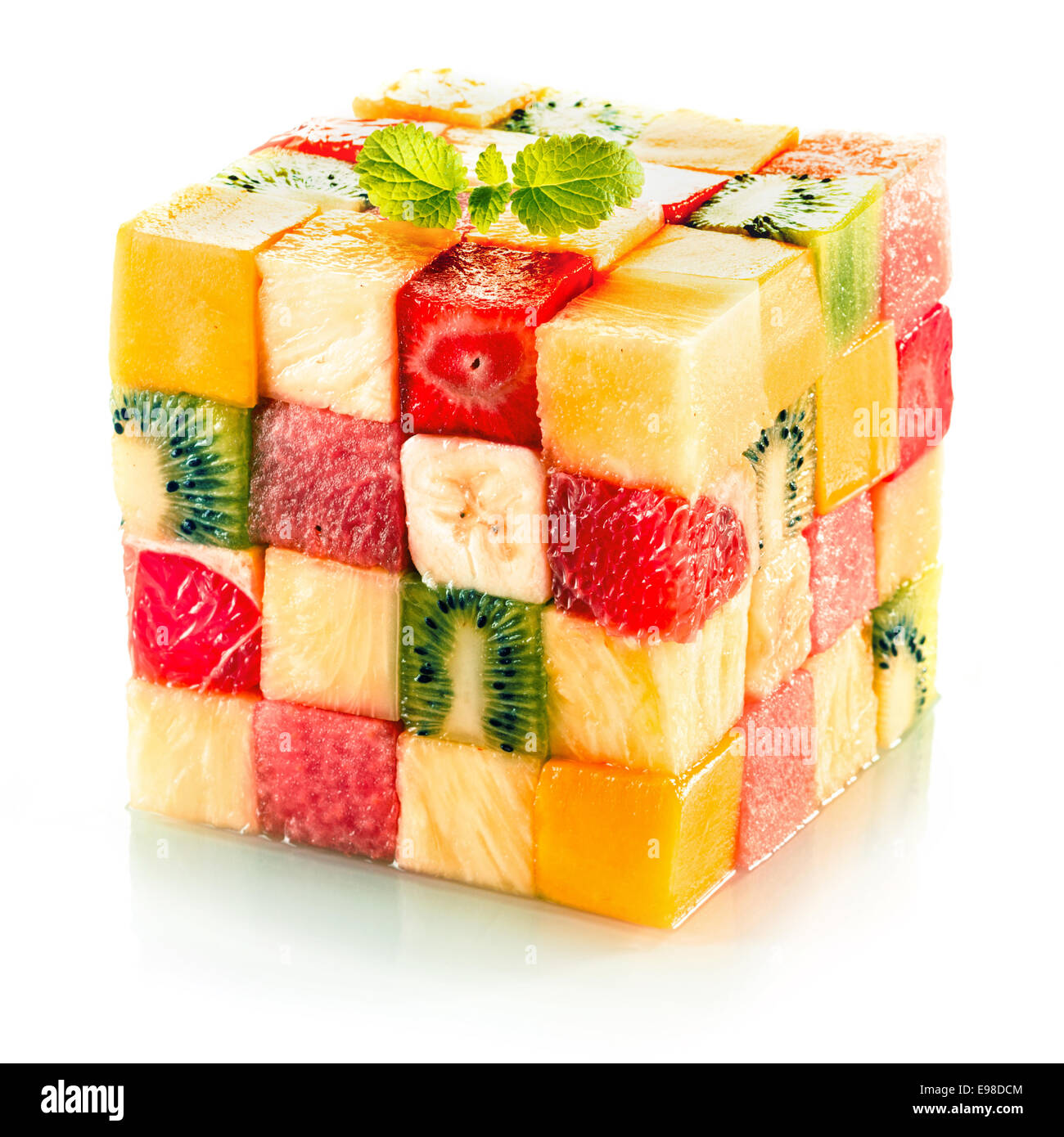Cube de fruits formés de petits carrés d'un assortiment de fruits tropicaux dans un arrangement de couleur y compris le kiwi, fraise, Orange, Banane et Ananas sur fond blanc Banque D'Images