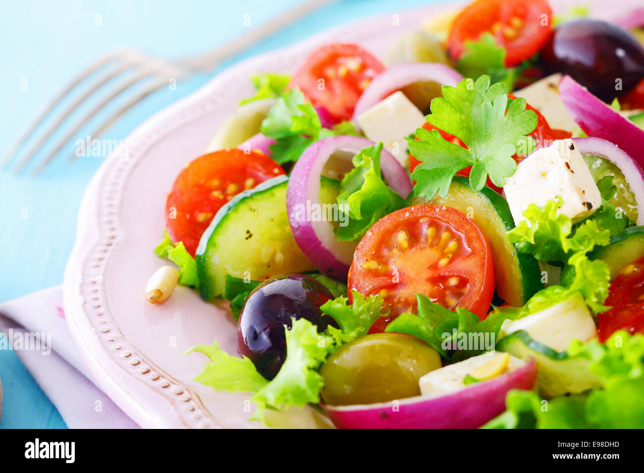 Salade de fruits frais avec du fromage feta , laitue croustillante, tomate cerise, concombre, d'oignon et les olives sur une plaque blanche Banque D'Images