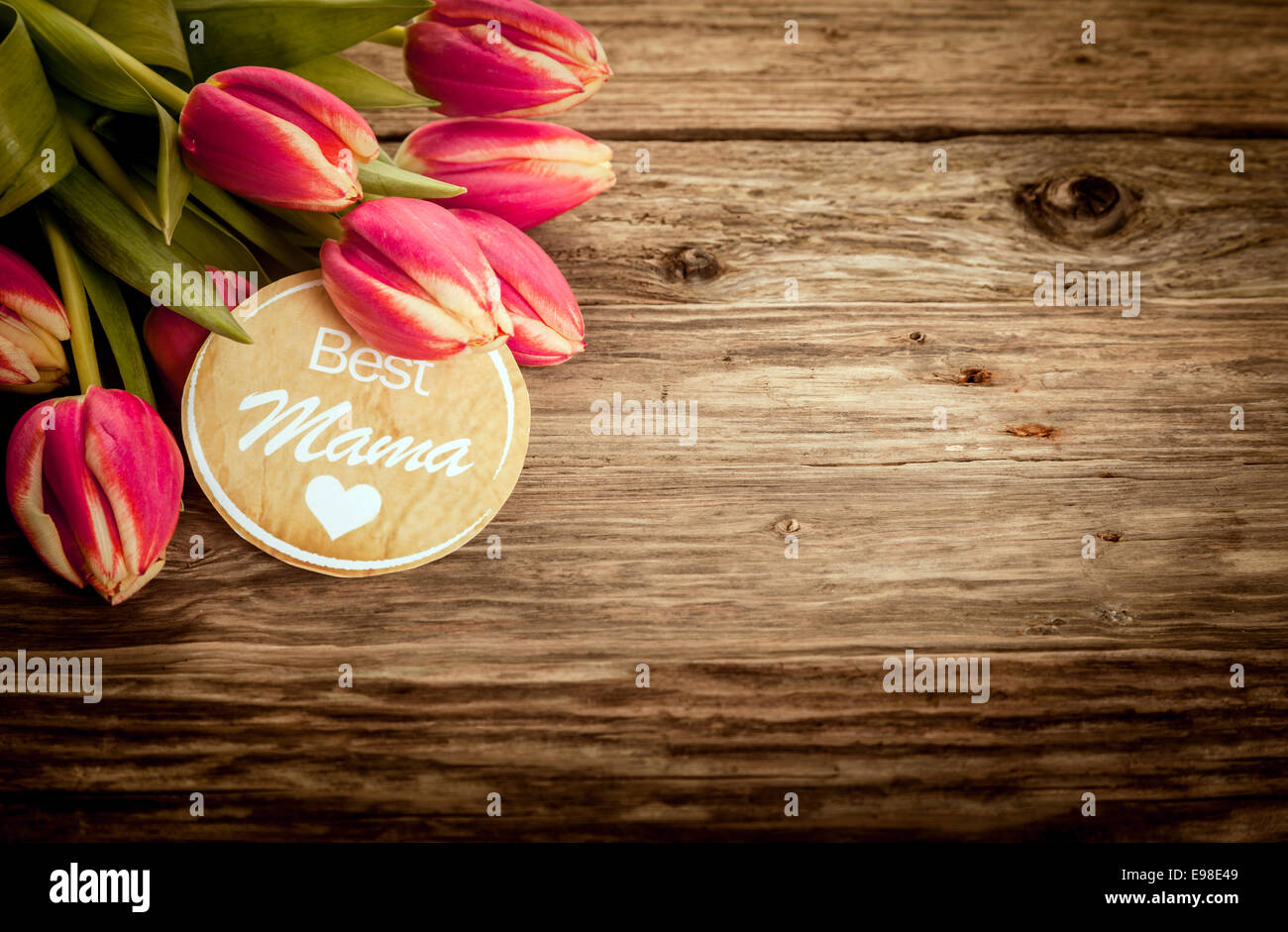 Meilleure Maman carte de souhaits sur grunge bois rustique avec un tas de tulipes rouges dans le coin et copyspace pour votre texte sur la fête des Mères ou pour une douche de bébé Banque D'Images