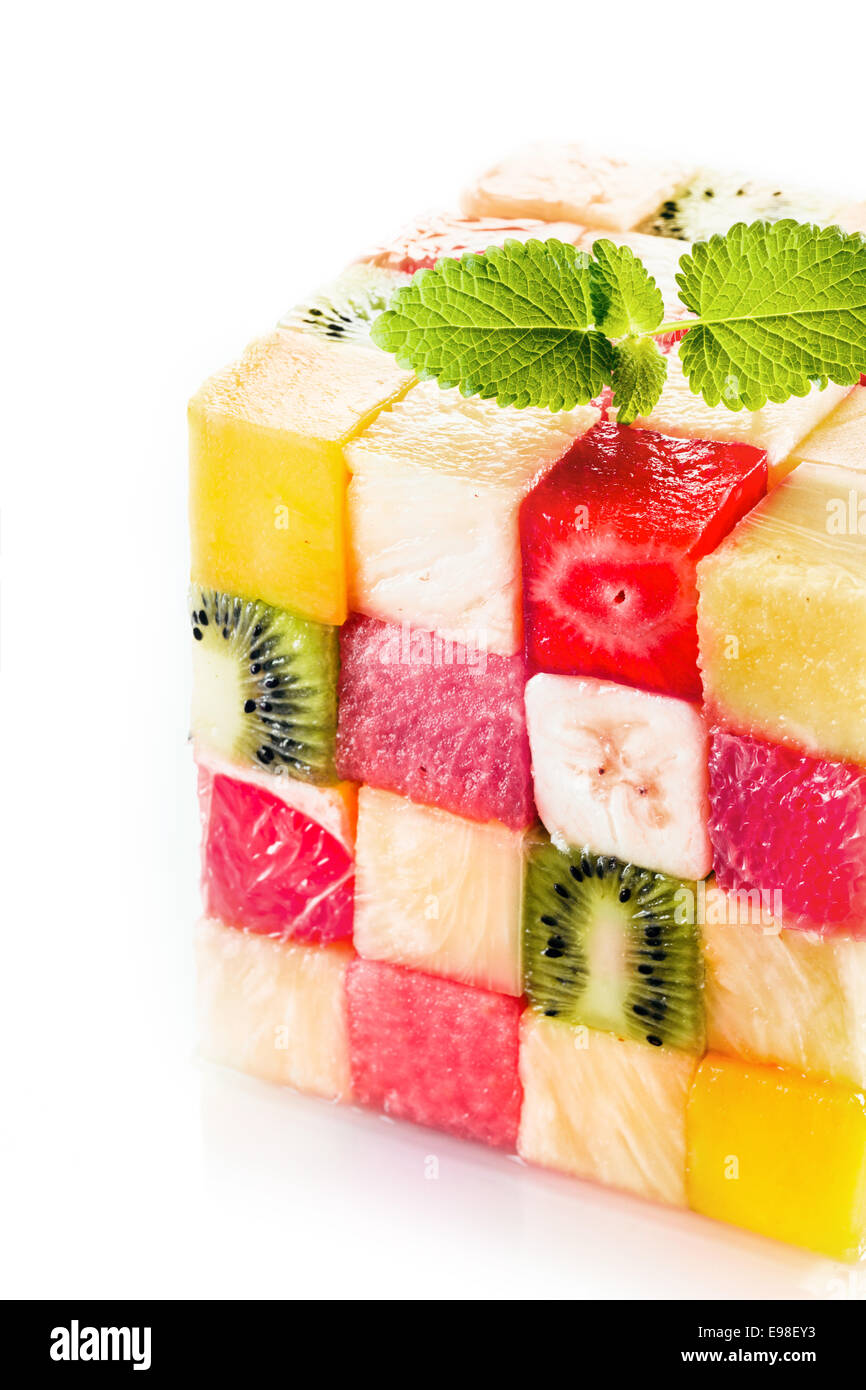 Cube décoratif de carrés aux fruits tropicaux colorés avec les kiwis, melon, pastèque, Banane et fraise garnie d'un brin de menthe pour un affichage buffet central Banque D'Images