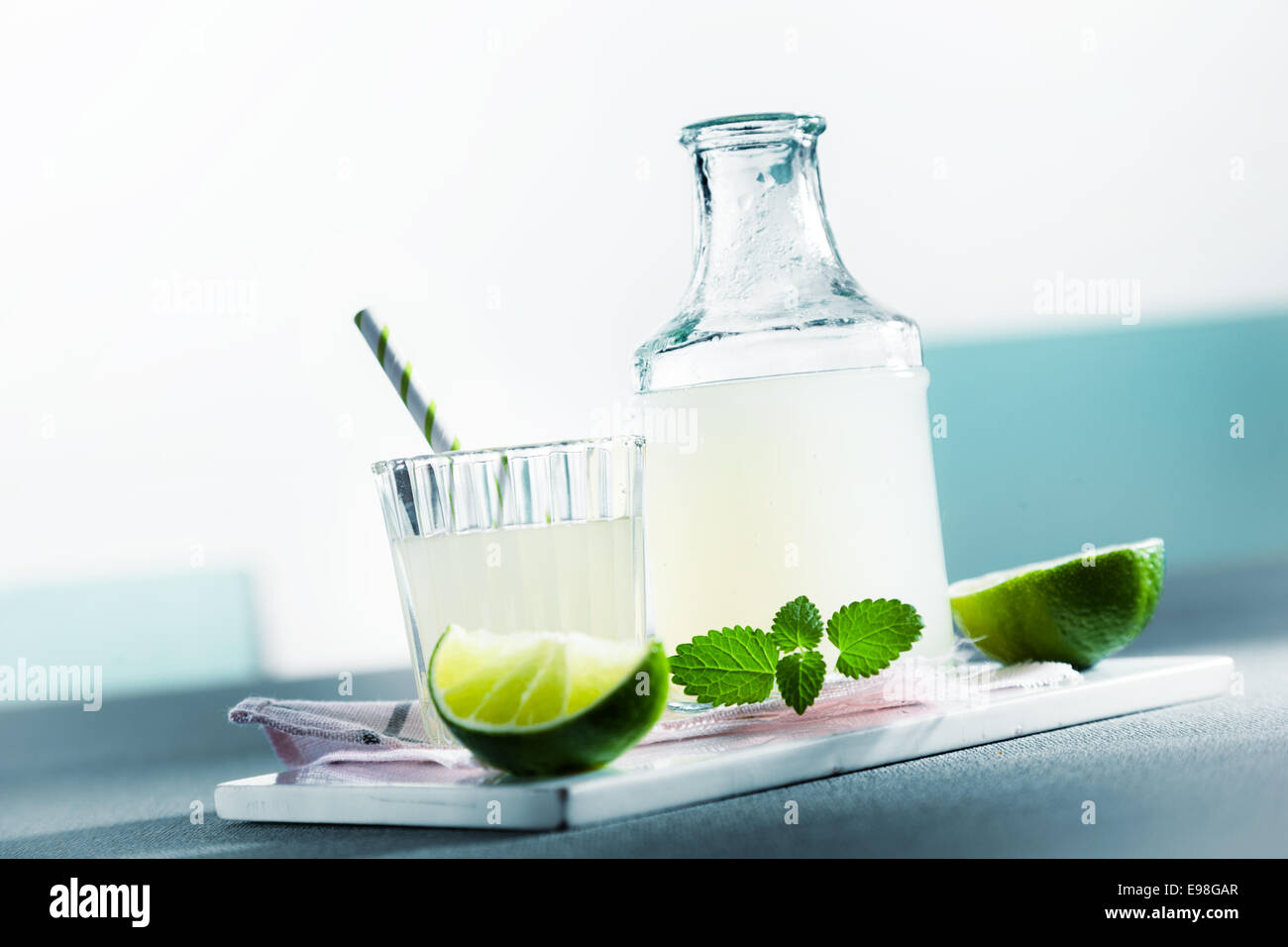 Bouteille de limonade acidulée rafraîchissante fraîches maison à la menthe servi dans un verre sur une table à l'extérieur sur un pique-nique estival, avec copyspace Banque D'Images
