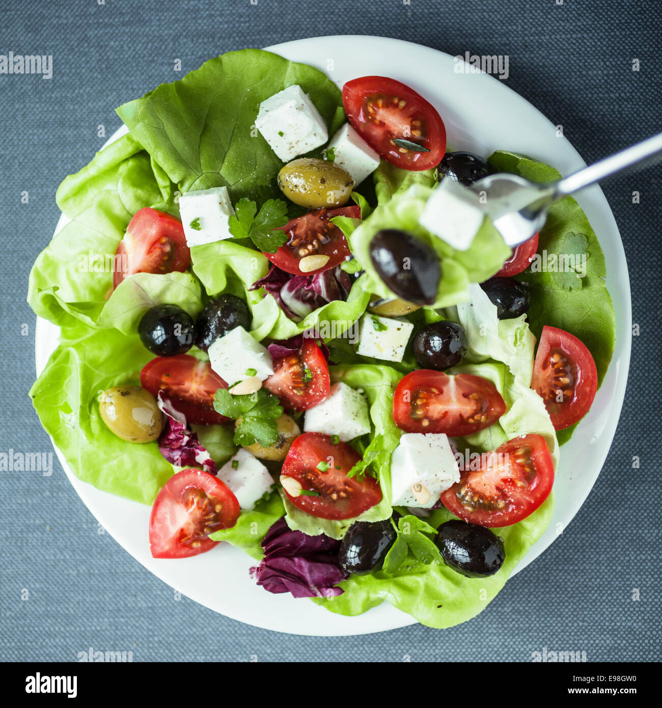 Assiette de Salade méditerranéenne saine avec fromage feta, olives noires et vertes, tomate et laitue , close up Vue de dessus en format carré Banque D'Images