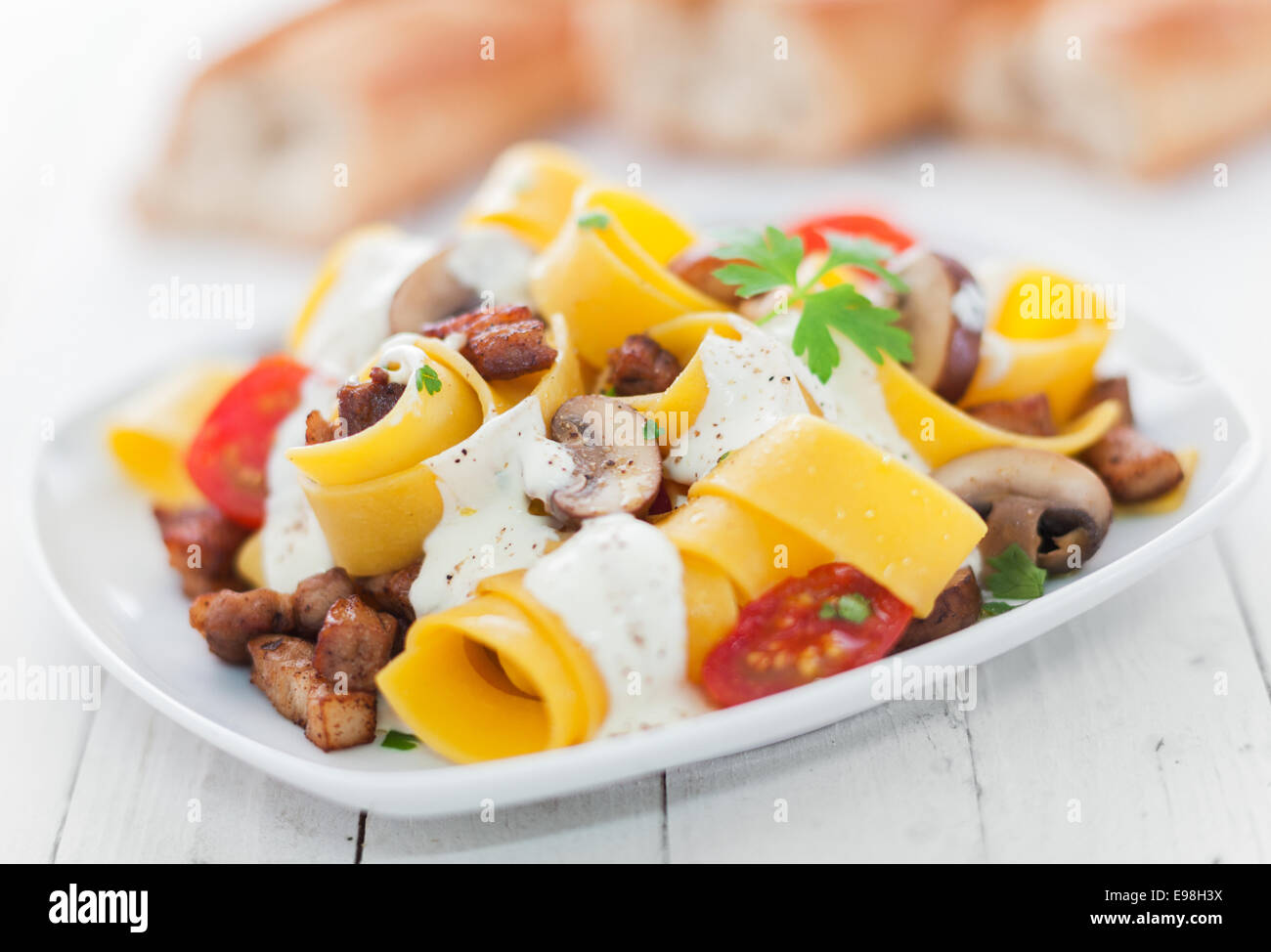 L'Italien de nouilles aux oeufs à la tomate et champignons arrosé d'une sauce à la crème aux herbes aromatiques de délicieuse cuisine italienne Banque D'Images