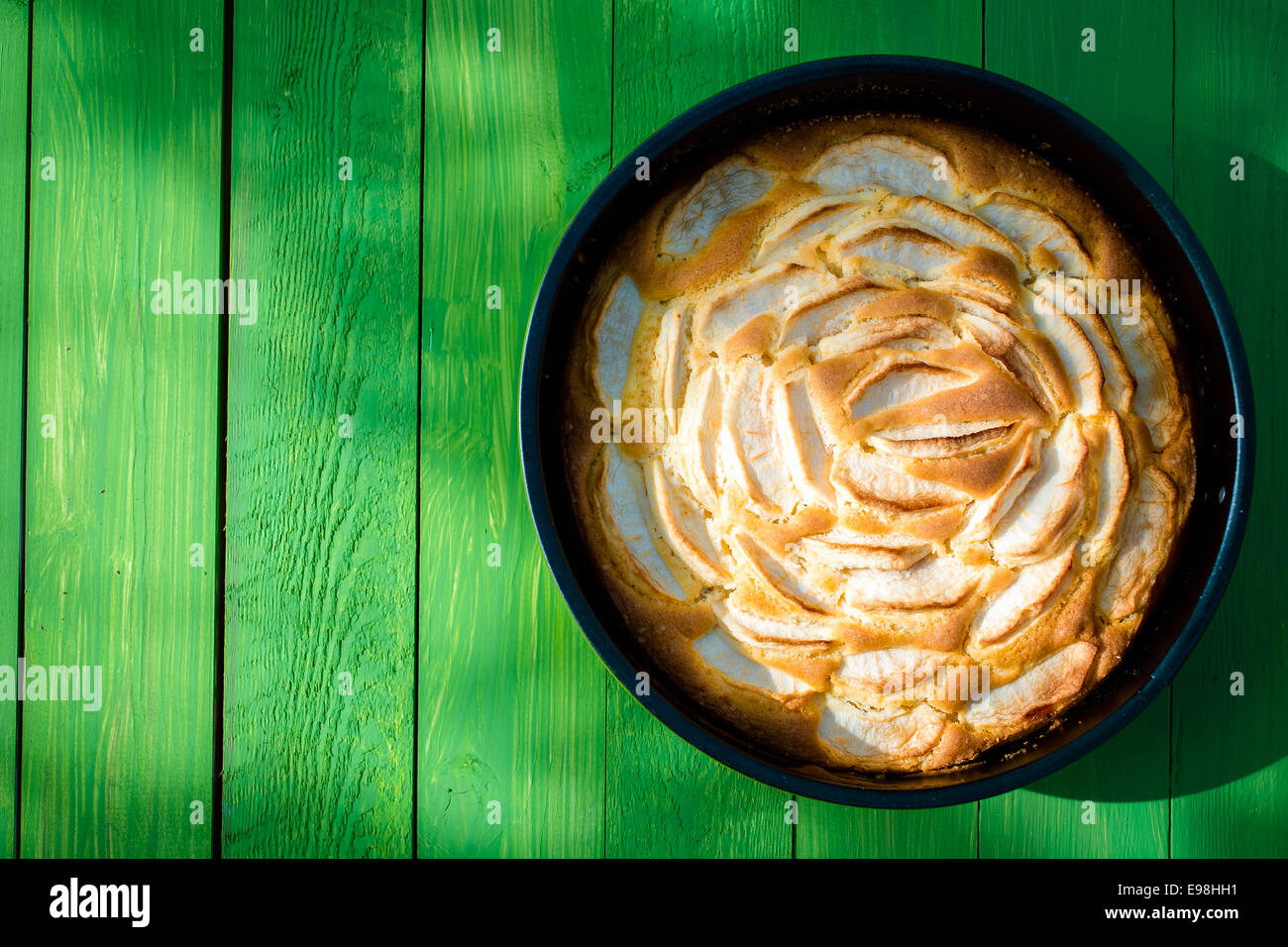 Appétissant du golden apple tart debout prêt à servir sur une table de jardin vert tacheté dans la lumière du soleil pour un pique-nique d'été savoureux Banque D'Images