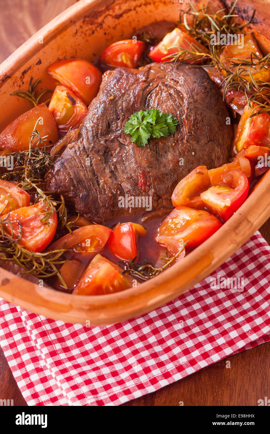 Rosbif avec tomates, herbes et d'une partie de bruni le boeuf braisé dans  une cocotte en terre cuite mijoté dans une sauce riche ou Photo Stock -  Alamy