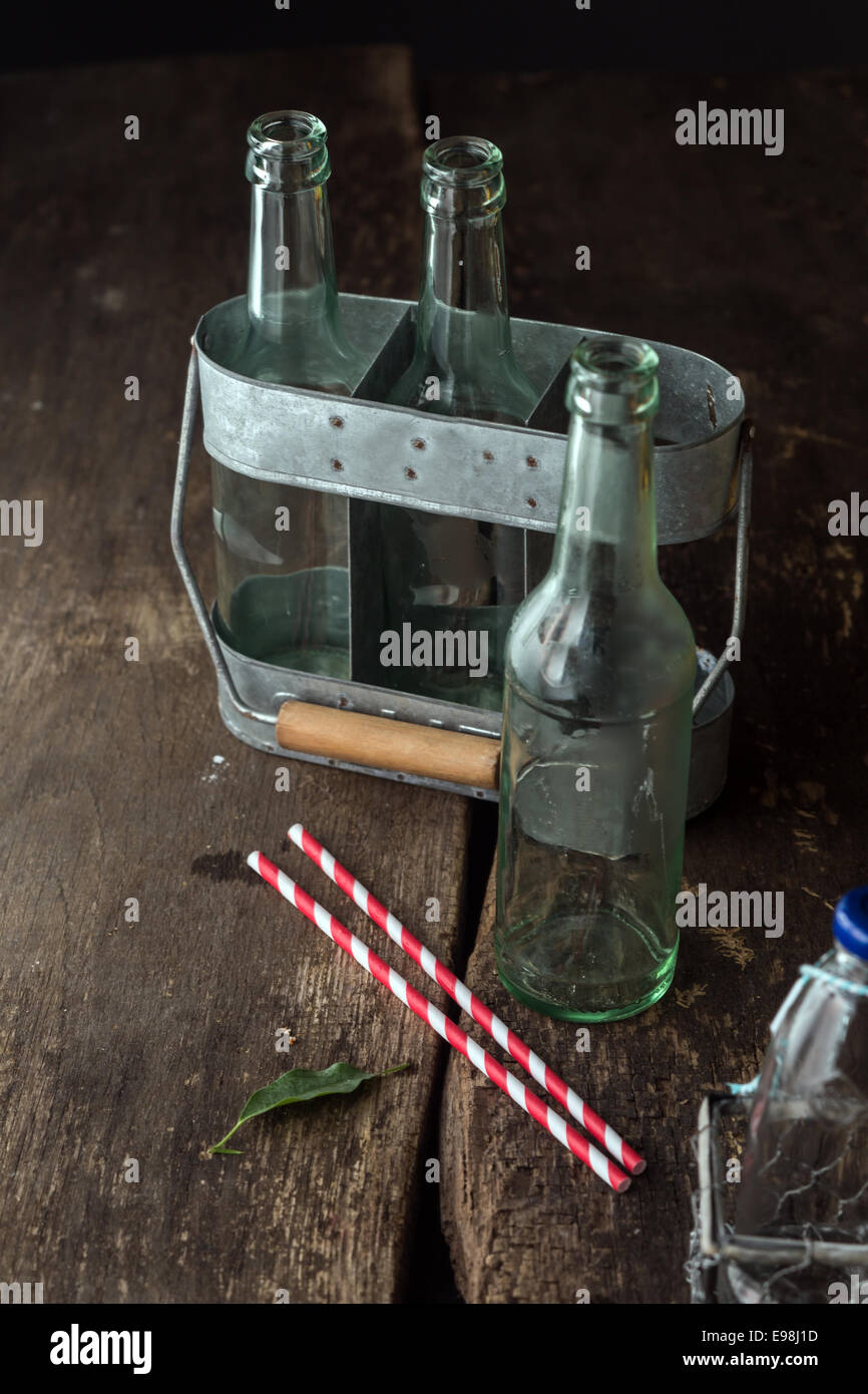 Des bouteilles vides dans le bac prêt à utiliser pour n'importe quel liquide sur table en bois brun Banque D'Images