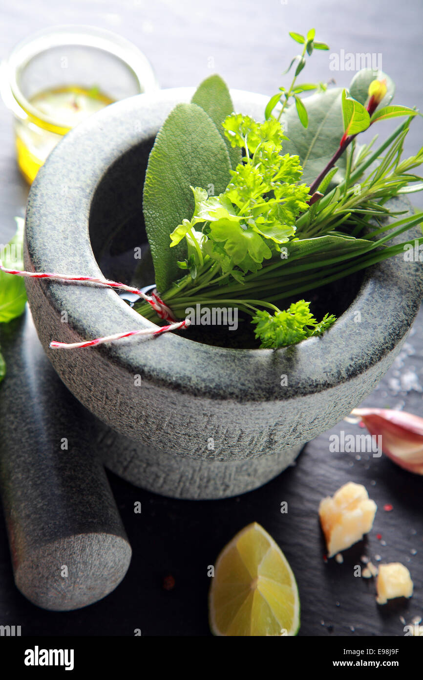 Herbes macro sur pierre Mortier et pilon, isolé sur fond de bois. Banque D'Images