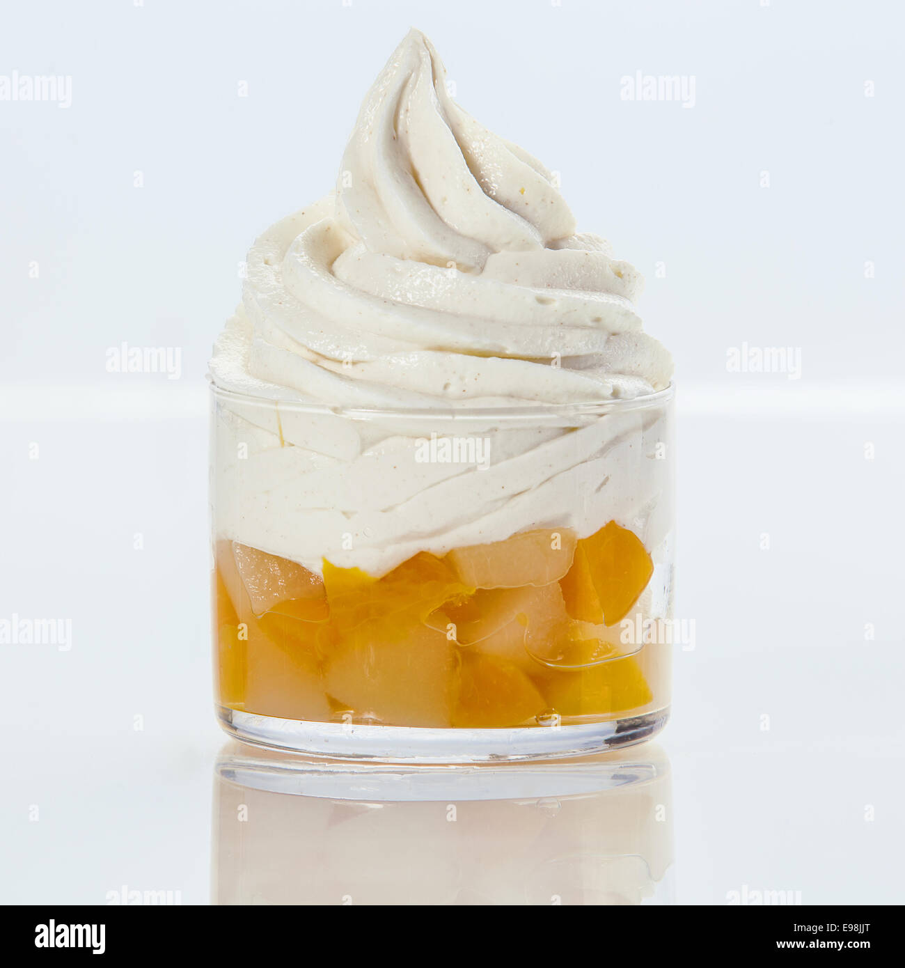 Rafraîchissant délicieux yogourt glacé de twirl avec salade de fruits frais servis dans un plat en verre sur un fond blanc , format carré Banque D'Images