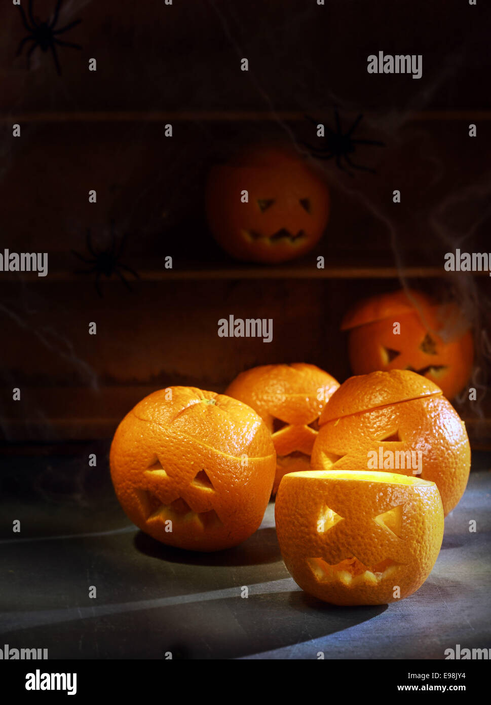 Groupe de Six Jack o lanterne taillée dans les oranges avec des étagères en arrière-plan Banque D'Images