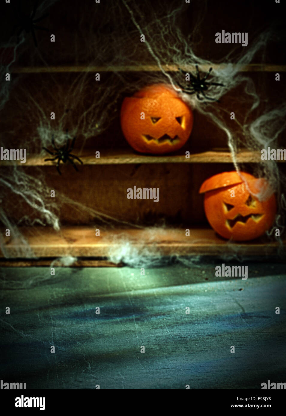 Deux Halloween Jack o lanterne taillée dans les oranges et les araignées Les araignées sur les étagères avec en arrière-plan flou avec l'espace d'avant-plan Banque D'Images