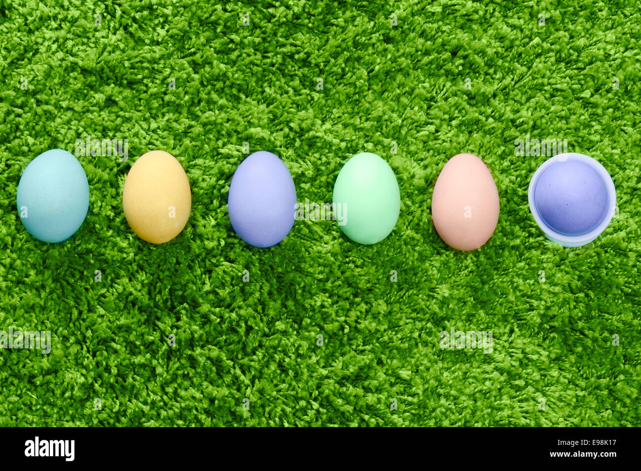Œufs de Pâques colorés dans une rangée fils fond vert Banque D'Images