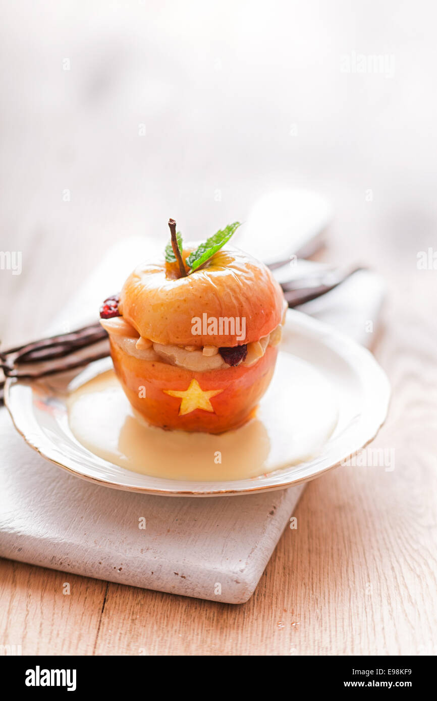 Halloween farcies avec un dessert apple bouche béante remplie de dents et une étoile dorée garnie d'une feuille de menthe fraîche et servi sur une plaque blanche avec copyspace pour votre message d'invitation ou Banque D'Images