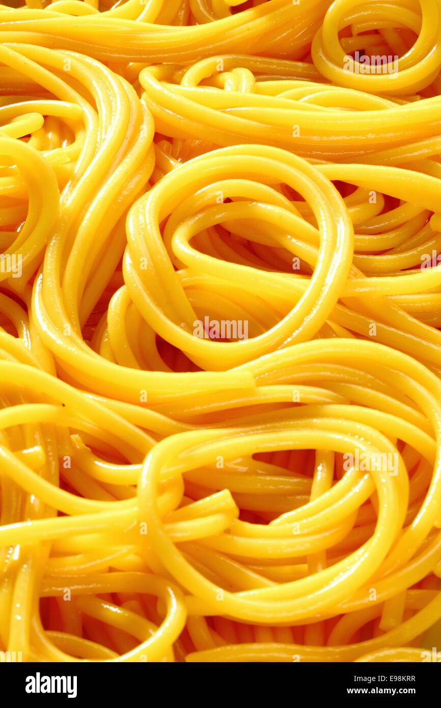 Gros plan du spaghetti fraîchement bouillie lovés dans des motifs aléatoires pour un arrière-plan intéressant. Banque D'Images