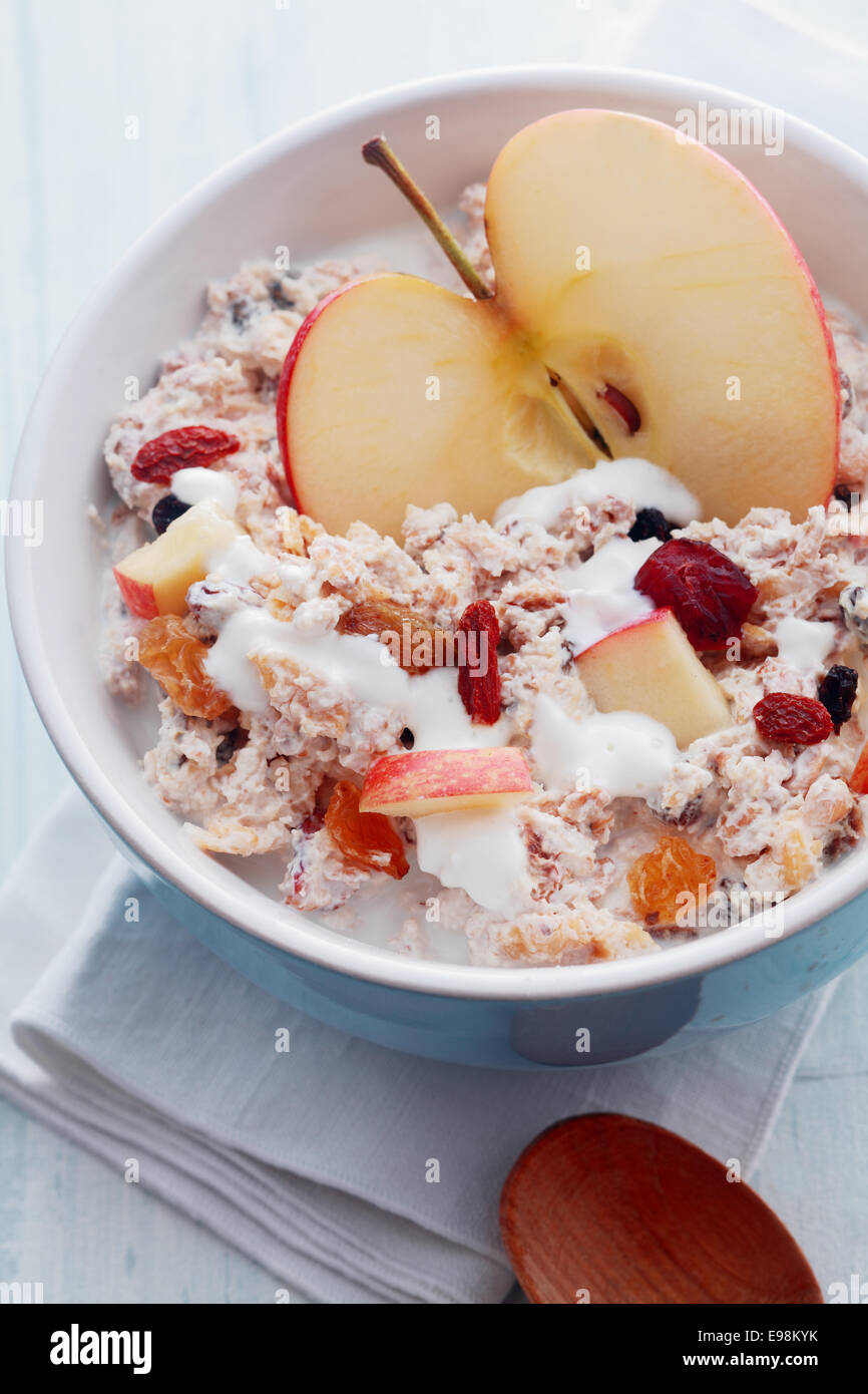 Vue de dessus d'un bol de muesli avec pommes fraîches, fruits secs et noix servi avec du lait pour l'un de vitalité Banque D'Images