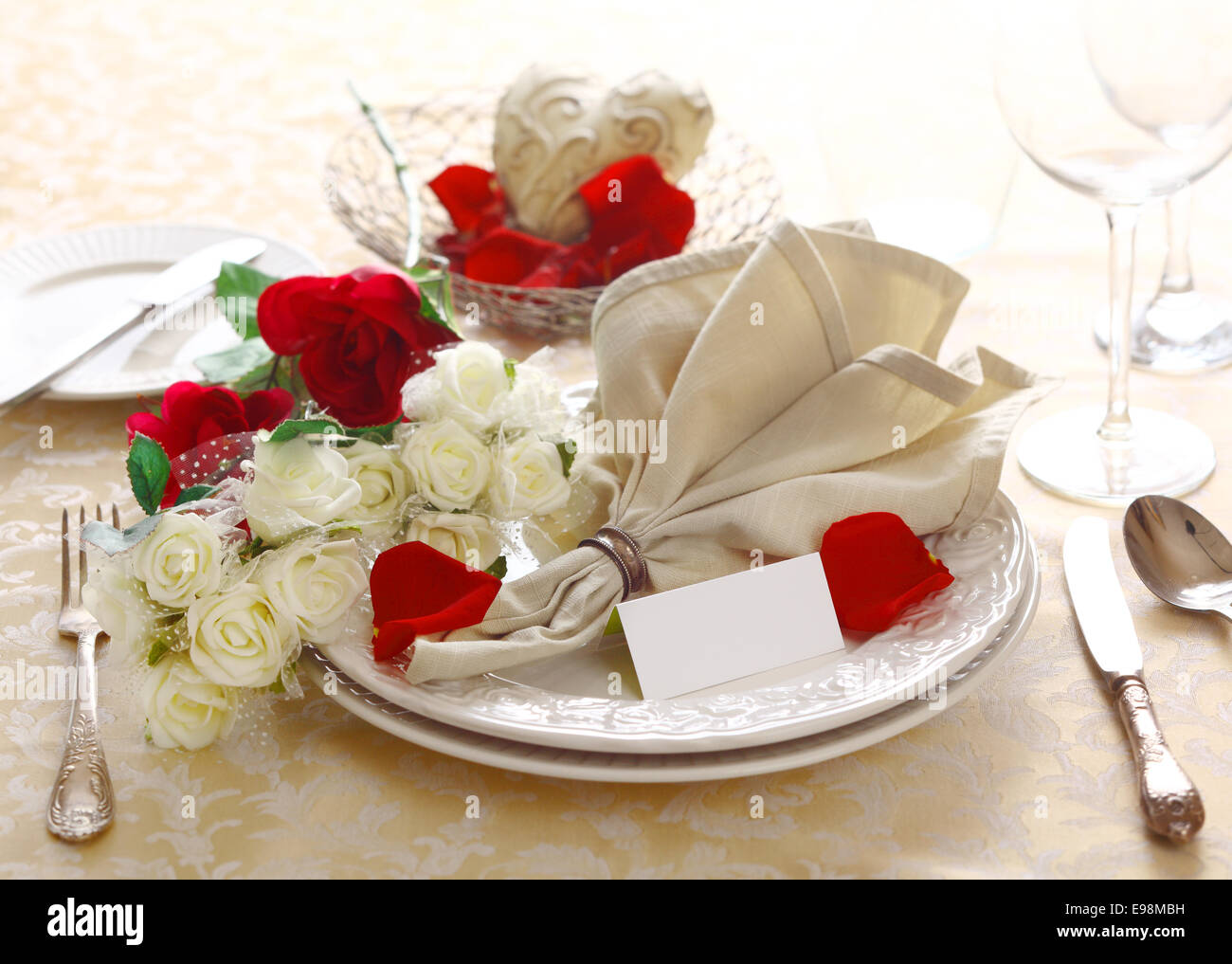 Pretty pink anniversaire ou mettre la table de Saint Valentin roses rouges et blanches avec une serviette en éventail et carte vierge Banque D'Images