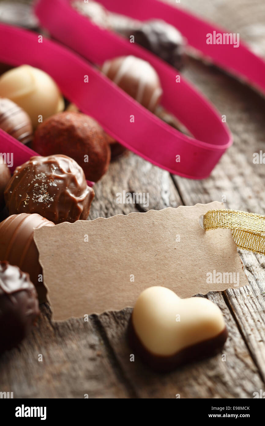 Truffe en forme de cœur avec une carte message avec un ruban rose sur fond de bois Banque D'Images