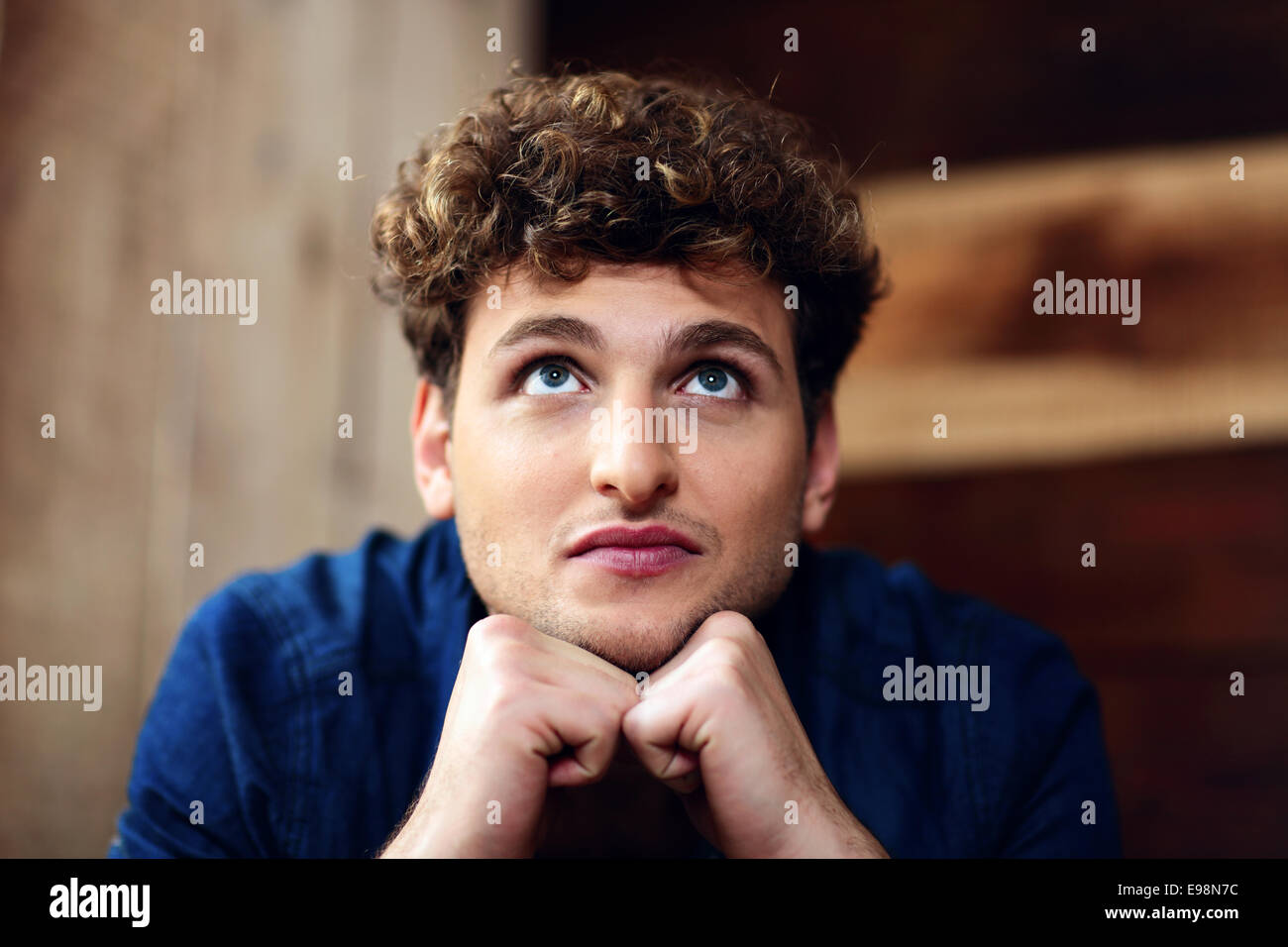 Portrait of a smiling man with curly hair looking up Banque D'Images