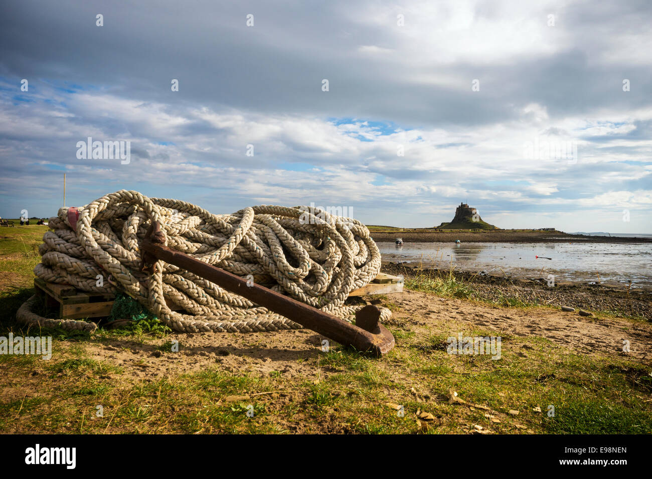 L'Île Sainte.old anchor et corde enroulée avec Château de Lindisfarne et le port en arrière-plan. Banque D'Images