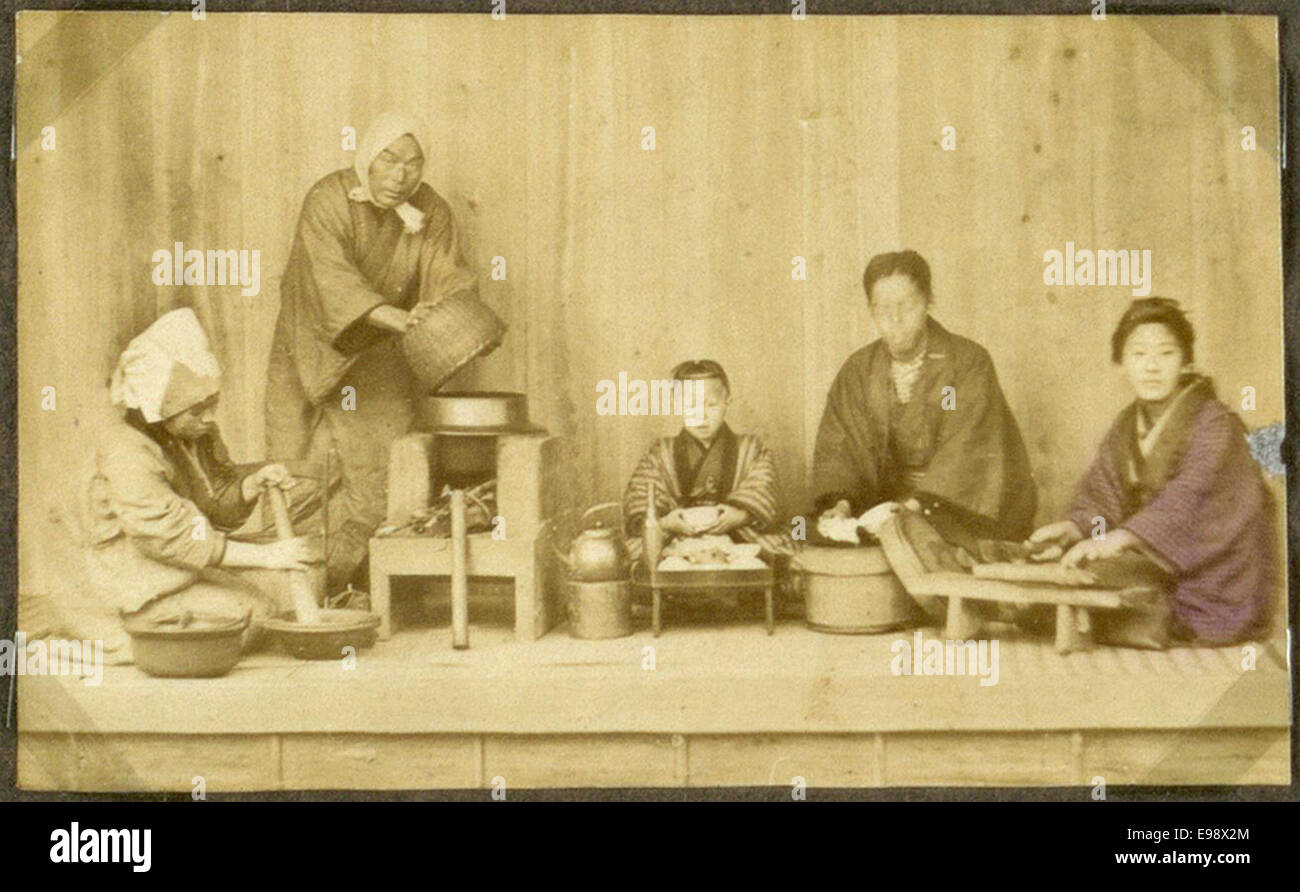 Cette photographie représente une famille au Japon pendant les repas. L'image capture un cadre familial traditionnel, reflétant les coutumes et les pratiques culturelles de l'époque au Japon du début du XXe siècle. Banque D'Images