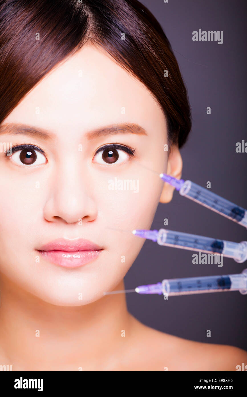 Belle femme asiatique obtient l'injection dans son visage. Banque D'Images